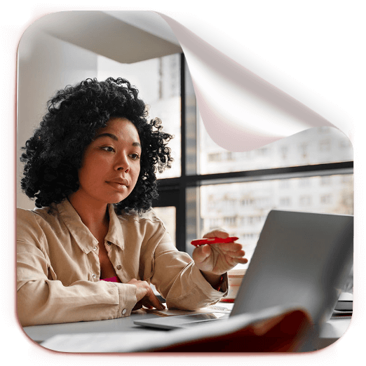 Moça trabalhando concentrada, olhando para a tela do ccomputador.